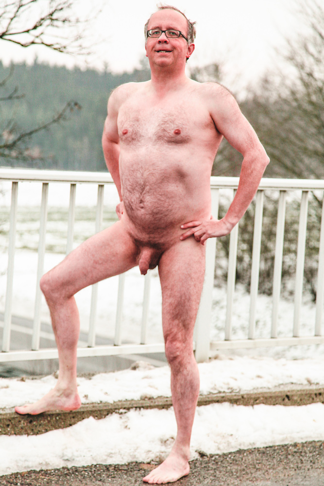 Man posing naked on highway bridge