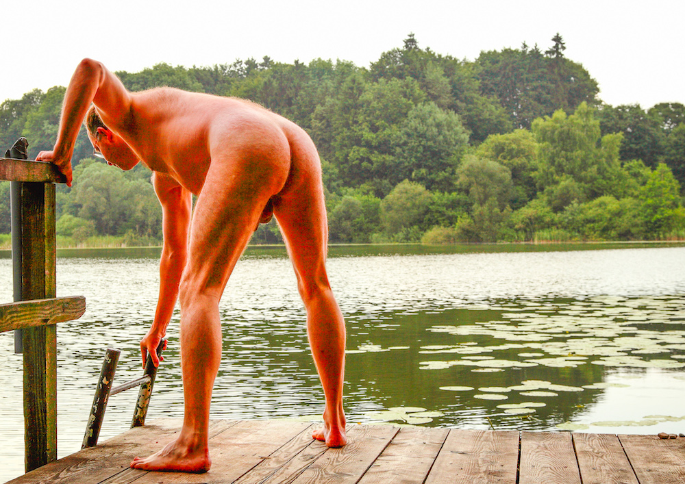 Stark naked man is about to climb into the water