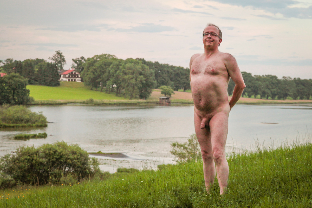 Naked man posing in the grass